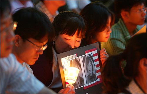 12일 서울 광화문에서 열린 '고 신효순·심미선 3주기 추모 촛불대행진'에서 한 참석자가 효순·미선양을 추모하는 피켓을 들고있다. 